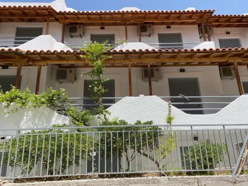 a white house with a fence in front of it at Georgina in Agia Marina Aegina
