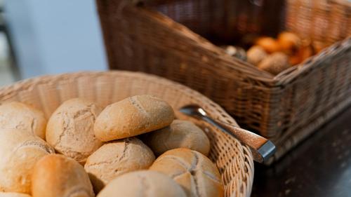 a basket of loaves of bread next to baskets of bread at Taste Hotel Jettingen in Jettingen-Scheppach
