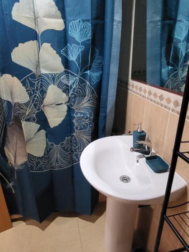 uma casa de banho com um lavatório e uma cortina de chuveiro azul em ¡Apartamento en primera línea con terraza y cerca de la piscina comunitaria! em Vera