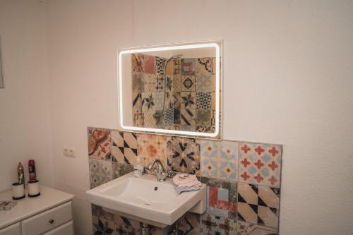 a bathroom with a sink and a mirror on the wall at Ferienwohnung in Jülich, nähe Aachen & Köln in Jülich