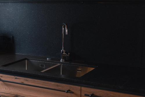 a kitchen sink with a faucet on a black wall at Mountain Residence Bergrichter in Sankt Anton am Arlberg
