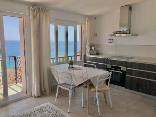 eine Küche mit einem Tisch und Stühlen mit Meerblick in der Unterkunft Del Sol in Altea