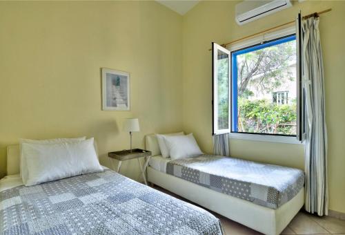 a bedroom with two beds and a window at Villa Melina in Nisakion