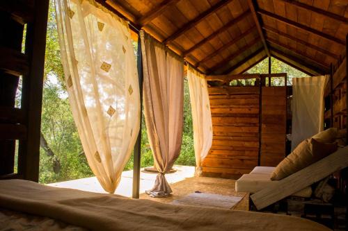 een kamer met een bed en gordijnen in een hut bij Pelekas Olive Grove Oasis Room No4 in Pelekas