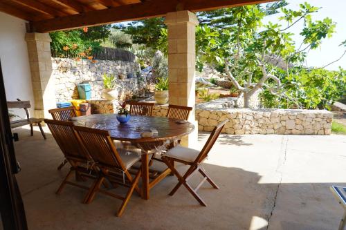 una mesa de madera y sillas en un patio en Case Vacanza Le Arcate, en Morciano di Leuca