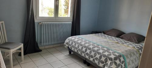 une chambre avec un lit, une fenêtre et une chaise dans l'établissement MAISON PROVENCE AVEC PISCINE PRIVATIVE, à Nyons