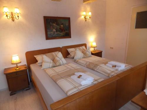a large bed in a bedroom with two lamps at Pension Hoffmann in Trebra