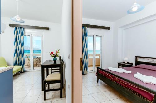 a bedroom with a bed and a view of the ocean at Asterina Seaside Apartments in Kalyves