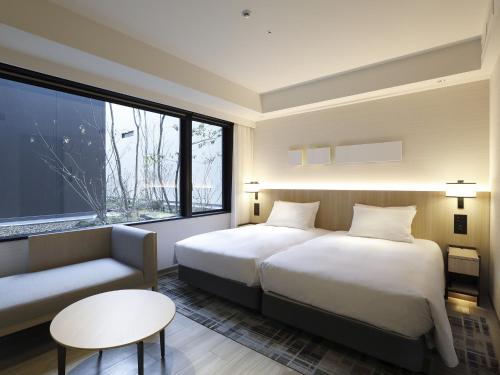 a hotel room with two beds and a window at Hyatt Place Kyoto in Kyoto