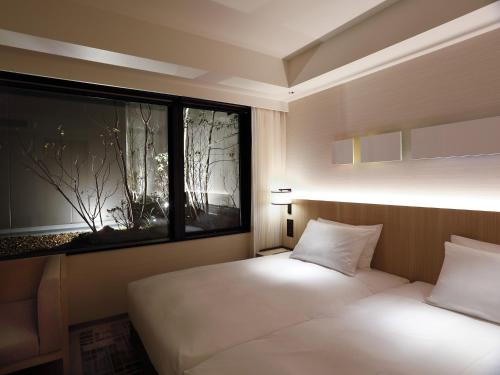 a bedroom with two beds and a large window at Hyatt Place Kyoto in Kyoto