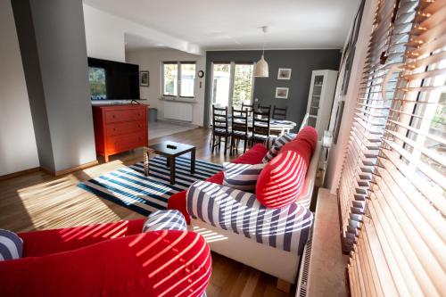 a living room with red and white striped couches at Wila Dom Nad Jeziorem Mazury in Sorkwity