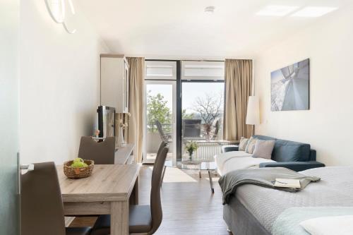 ein Wohnzimmer mit einem Bett, einem Tisch und einem Sofa in der Unterkunft Miramar Wohnung 312 in Grömitz
