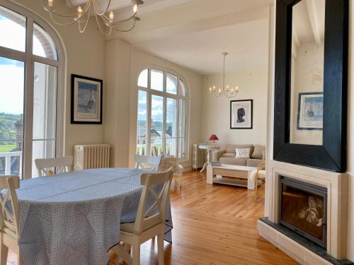 sala de estar con mesa y chimenea en VILLA ALBION, en Hautot-sur-Mer