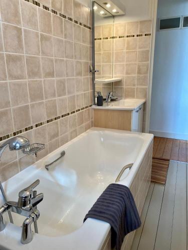 une salle de bain avec une baignoire blanche et un lavabo dans l'établissement VILLA ALBION, à Hautot-sur-Mer