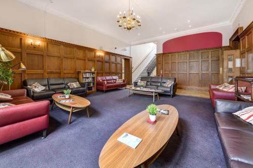 a waiting room with couches and tables at Lee Abbey London in London