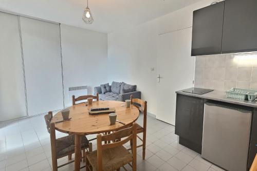 a kitchen with a table and chairs in a room at Confortable appartement pour 4 personnes proche de la plage in Valras-Plage