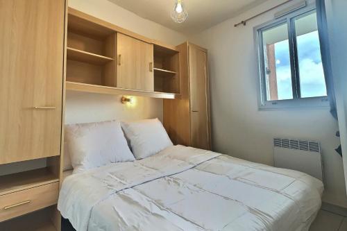 a bedroom with a large bed and a window at Confortable appartement pour 4 personnes proche de la plage in Valras-Plage