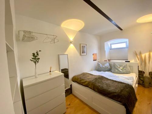 ヴィンニンゲンにあるFerienwohnung Zur Alten Schmiedeのドレッサーと鏡付きのベッドのある寝室