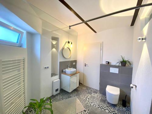 ヴィンニンゲンにあるFerienwohnung Zur Alten Schmiedeの洗面台とトイレを備えた白いバスルーム