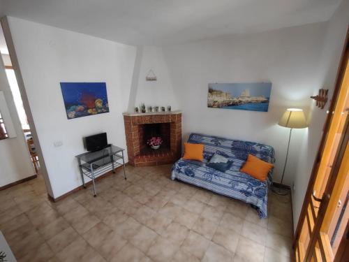 sala de estar con sofá y chimenea en Casa con giardino 'Luna e Poesia', en Torre dell'Orso
