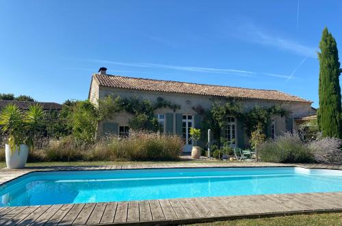 une villa avec une piscine en face d'une maison dans l'établissement M de Maumey, à Sainte-Radegonde
