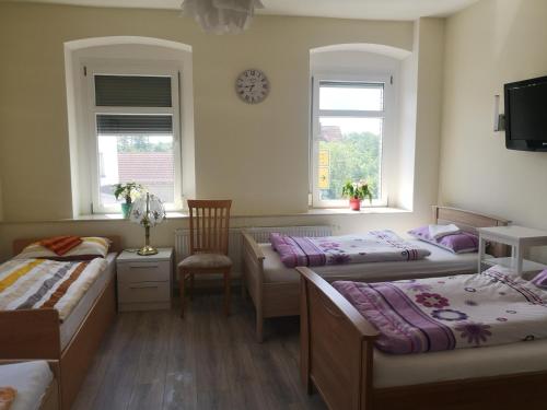 a room with three beds and a clock on the wall at Schmetterling Zimmer in Bad Lausick