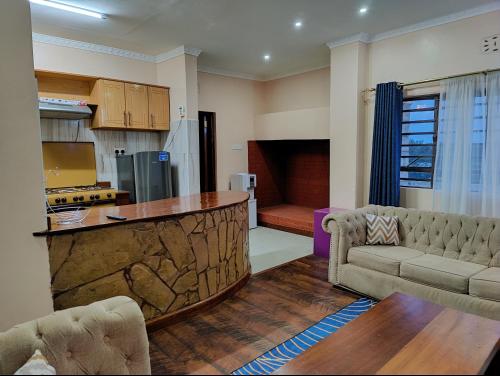 a kitchen and living room with a bar and a couch at Fadhili House in Naivasha