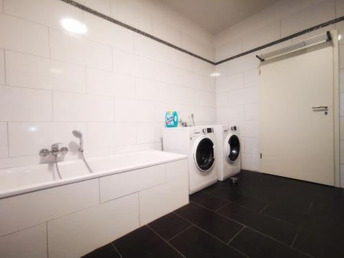 eine weiße Waschküche mit Waschmaschine und Trockner in der Unterkunft Quartier Langenstrich in Neunkirchen
