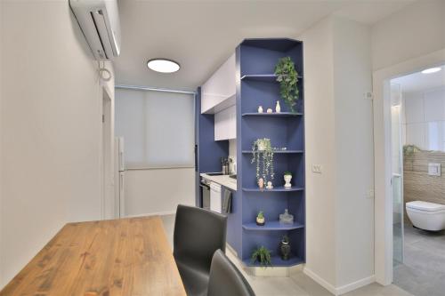 a dining room with a table and a blue shelf at Cozy and stylish 1-bedroom apartment in Netanya