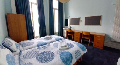a bedroom with two beds and a desk and a chalkboard at Lee Abbey London in London
