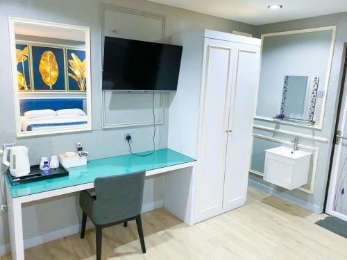 a room with a desk and a television in a room at 61 Hotel in Gua Musang