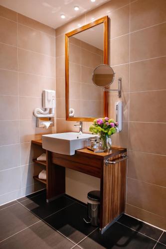 a bathroom with a sink and a mirror at Abbaye des Capucins Spa & Resort in Montauban
