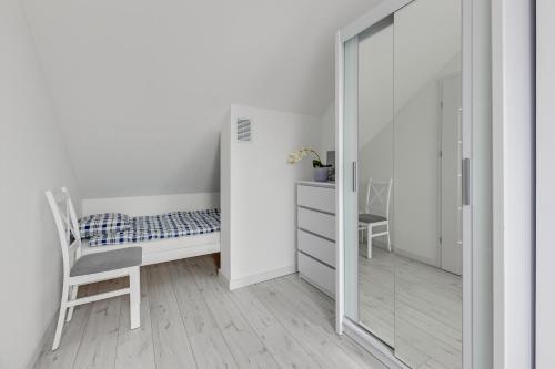 a bedroom with a mirror and a bed and a chair at Apartamenty Piamola Jantar Park in Jantar
