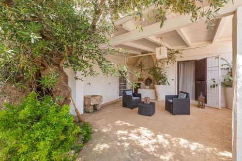 an outdoor patio with chairs and a tree at Masseria La Cazzigna by Perle di Puglia in Pezze di Greco