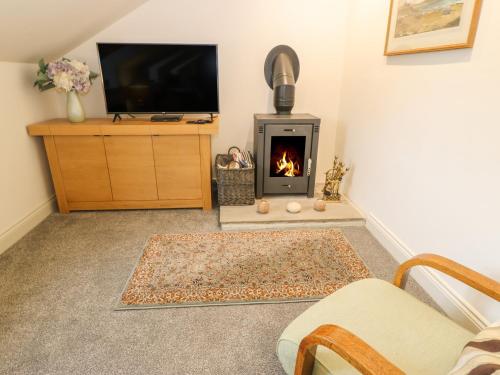 a living room with a fireplace and a tv at Woodlands in Keighley