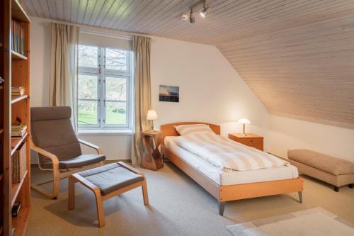 um quarto com uma cama king-size e uma cadeira em "Gästehaus Summersby" - Natururlaub mit exklusivem Landhausflair em Westfehmarn
