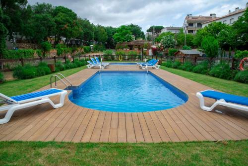 una piscina con 2 sillas y una terraza de madera en ACAMPALE - Camping Costa Brava - Calella de Palafrugell, en Calella de Palafrugell