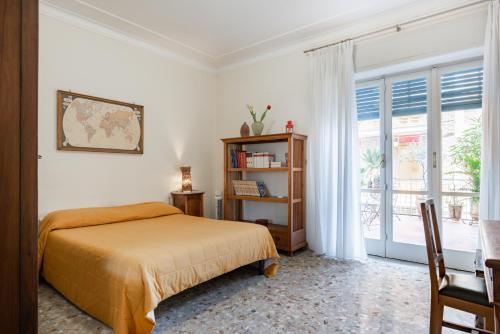 a bedroom with a bed and a book shelf and a window at Stadio & Villa Bellini Big APT with Terrace in Catania