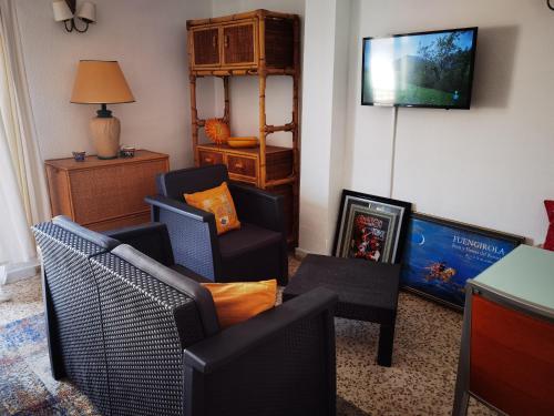 een woonkamer met stoelen en een flatscreen-tv bij Paraiso del Sol in Fuengirola