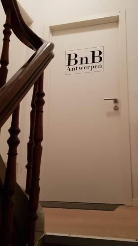 a white garage door with a sign on it at BnB Antwerpen - CHARMANT in Antwerp