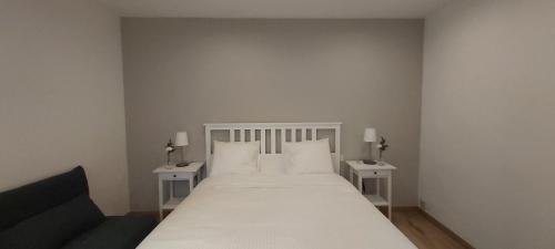 1 dormitorio con 1 cama blanca y 2 mesas en Homenfun Madrid Puerta del Sol en Madrid