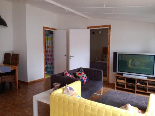 a living room with a yellow couch and a tv at Memories of Lisbon in Lisbon