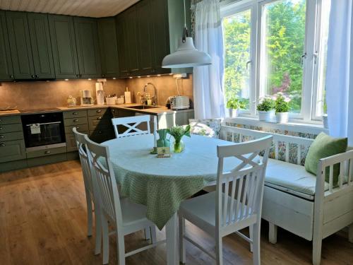 a kitchen with a table and chairs in a kitchen at Bolmen Bed - Vandrarhem in Ljungby