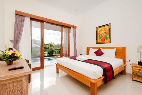 um quarto com uma cama, uma secretária e uma janela em Rara Guesthouse em Canggu
