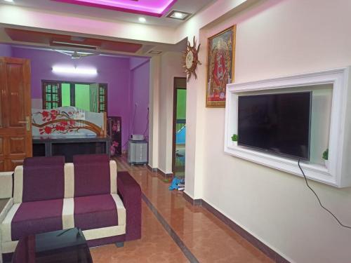 a living room with a large flat screen tv on a wall at Shanaya Holiday Apartment in Benaulim