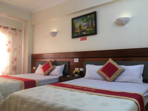 pokój hotelowy z 2 łóżkami i zdjęciem na ścianie w obiekcie Khách sạn NHẬT MINH Cửa Lò w mieście Cửa Lô