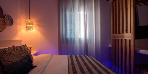 a bedroom with a bed and a window with a light at Kalestesia Suites in Akrotiri