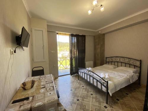 a bedroom with a bed and a table and a window at Bakuriani MIX 401G in Bakuriani