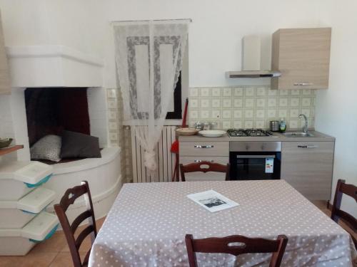 una cucina con tavolo e una cucina con piano cottura di Masseria Chianca - Le rose a Mottola