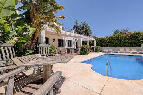 a villa with a pool and a table and chairs at El Cafetal de Veronica in Marbella
